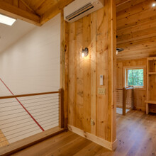 heat pump on the wall of a loft overlooking an indoor squash court
